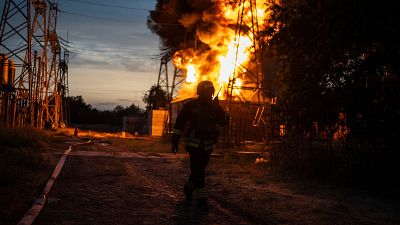 A Ukrainian firefighter talks on the radio while he works to extinguish the fire on the site of an electrical substation that was hit by Russian strike in Dnipropetrovsk.