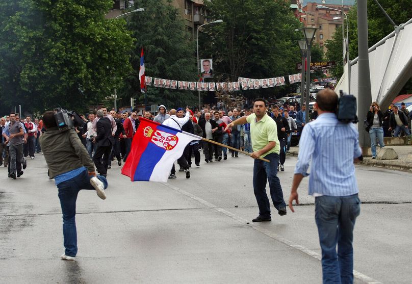 A Kosovo Serb holding a Serb flag tries to cross on the Albanian side of the town form the northern Serb-dominated part of Mitrovica on Sunday, May 30, 2010.