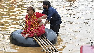 Un voluntario traslada a una residente en una carretera inundada por las fuertes lluvias en Vijayawada, la capital comercial de Andhra Pradesh, el 3 de septiembre 