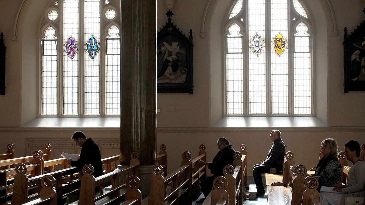 In this March 21, 2010 file phtoo, Roman Catholics listen during mass at St. Peter's Roman Catholic Cathedral, in West Belfast, Northern Ireland.