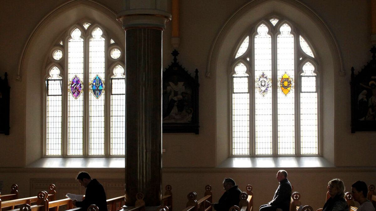 Nesta foto de arquivo de 21 de março de 2010, católicos romanos ouvem a missa na Catedral Católica Romana de São Pedro, em West Belfast, Irlanda do Norte.