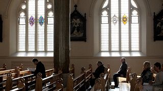 In this March 21, 2010 file phtoo, Roman Catholics listen during mass at St. Peter's Roman Catholic Cathedral, in West Belfast, Northern Ireland.