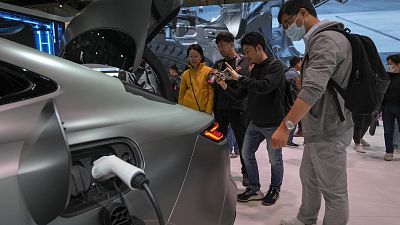 Visitors look at a Geely Galaxy E8 EV car model at the Auto China 2024 in Beijing in April