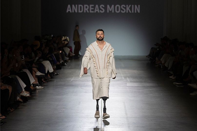 A Ukrainian war veteran wearing prosthetic takes to the runway to demonstrate outfit by designers Andreas Moskin and Andriy Bilous during Fashion Week show in Kyiv. 