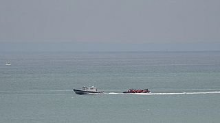 A boat thought to be with migrants is escorted by a vessel from the French Gendarmerie Nationale off the Wimereux beach, France