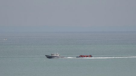 Un'imbarcazione con a bordo dei migranti viene scortata da una nave della Gendarmeria nazionale francese al largo della spiaggia di Wimereux, Francia, 4 settembre 2024