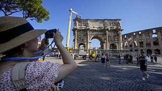 Bir turist, 4 Eylül 2024, Çarşamba günü Roma'da, Kolezyum yakınlarındaki M.S. 315 tarihli Konstantin Takı'nın fotoğraflarını çekiyor