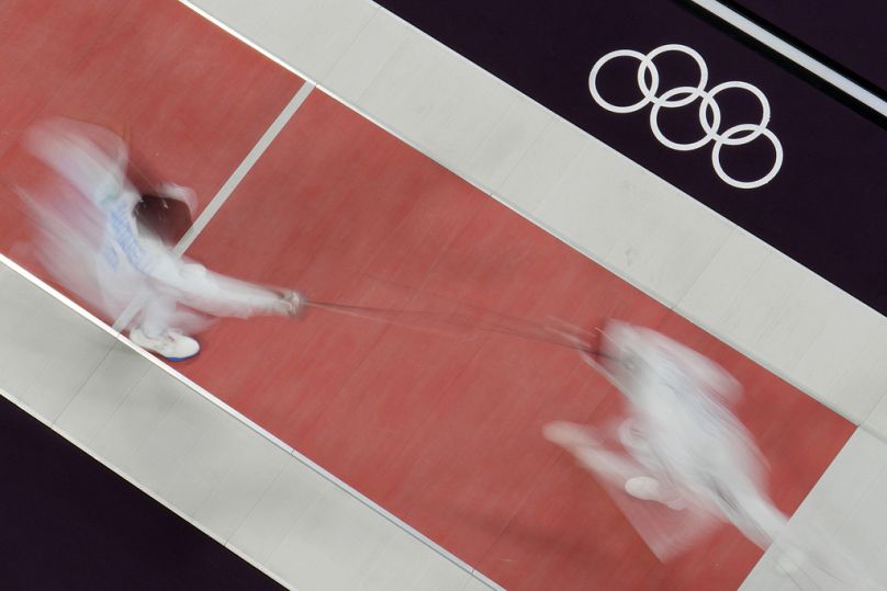 Andrea Santarelli of Italy, left, competes with Egypt's Mohamed Elsayed in the men's epee individual round of 16 match at the 2024 Summer Olympics, July 2024