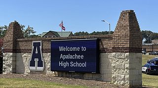 As forças da ordem chegam enquanto os alunos são evacuados para o estádio de futebol depois de o campus da escola ter sido colocado em confinamento na Apalachee High School em Winder, Geórgia, na quarta-feira.