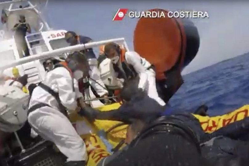 Una motovedetta della Guardia Costiera italiana che salva i migranti da una nave che sta affondando al largo di Lampedusa, Italia