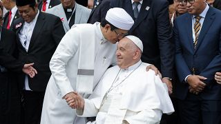 Pope Francis, right, and the Grand Imam of Istiqlal Mosque Nasaruddin Umar shakes hands during a family photo.