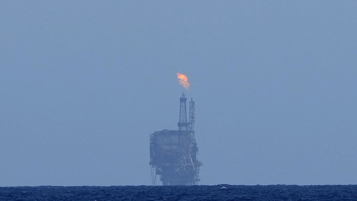 An oil platform is visible on the horizon in international waters zone near Libya, Mediterranean Sea