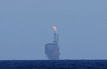 An oil platform is visible on the horizon in international waters zone near Libya, Mediterranean Sea