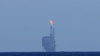 An oil platform is visible on the horizon in international waters zone near Libya, Mediterranean Sea