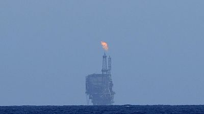 An oil platform is visible on the horizon in international waters zone near Libya, Mediterranean Sea