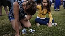 Brandy Rickaba and her daughter Emilie pray during a candlelight vigil for the slain students and teachers at Apalachee High School, Wednesday, Sept. 4, 2024, in Winder, Ga.