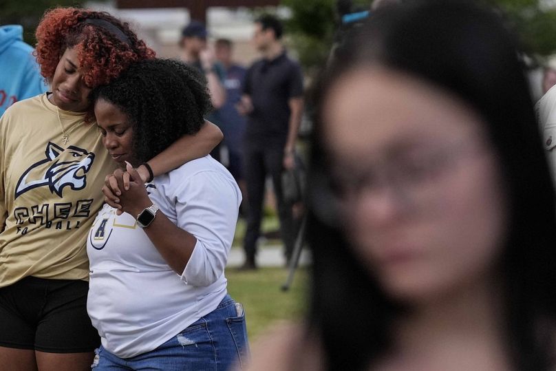 Mourners pray during a candlelight vigil for the slain students and teachers at Apalachee High School, Wednesday, Sept. 4, 2024, in Winder, Ga.