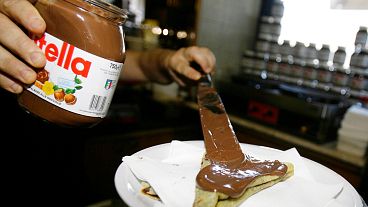 A bartender spreads Nutella on a crepe in a creperie in Rome.