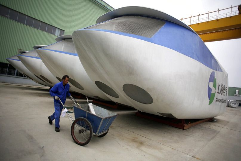 An employee pushes the cleaning cart next a wind turbine outside the assembly workshop, April 2012