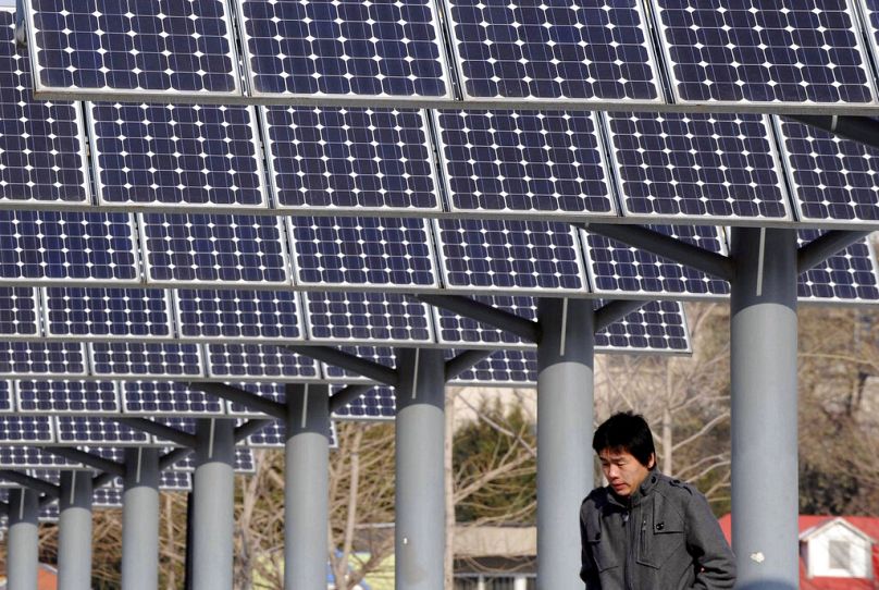 A man walks past a solar power plant in Shenyang, in northeast China's Liaoning province, December 2009