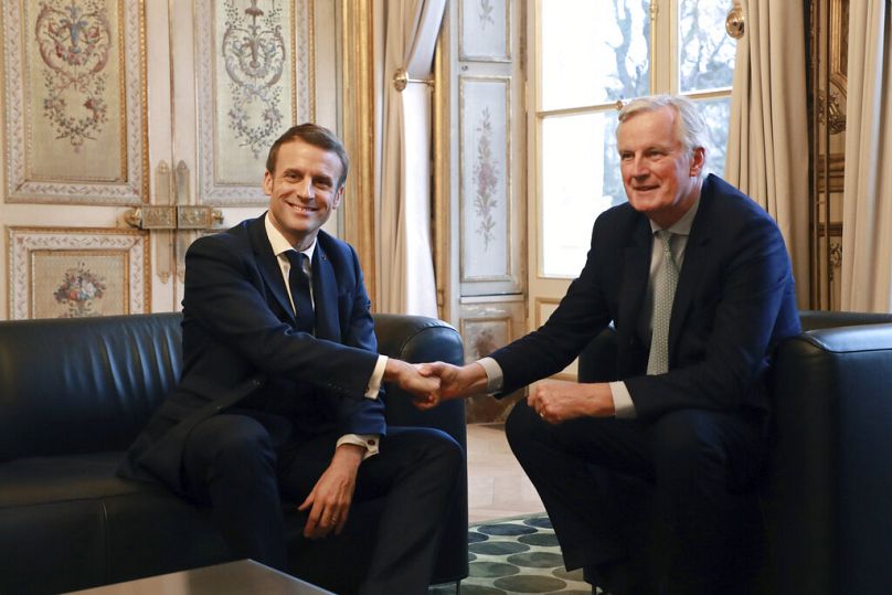 French President Emmanuel Macron, left, shakes hands with European Union chief Brexit negotiator Michel Barnier at the Elysee Palace in Paris, Friday, Jan. 31, 2020.