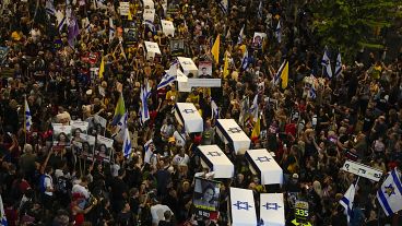 People carry mock coffins covered with Israeli flags representing the 27 hostages whose bodies have been recovered from Gaza, September 5, 2024