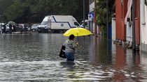 Μια γυναίκα περπατάει μέσα από τα νερά της πλημμύρας λόγω της έντονης βροχόπτωσης σε δρόμο του Μιλάνου, 5 Σεπτεμβρίου 2024