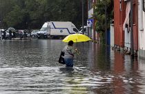 Una mujer vadea el agua inundada por las fuertes lluvias en una calle de Milán, el 5 de septiembre de 2024.