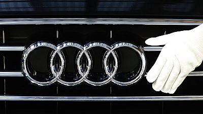 Сотрудник немецкого автопроизводителя Audi закрепляет эмблему на капоте автомобиля во время сборки моделей Audi A 8 на производственной площадке в Неккарсульме, Германия, четверг, 21 мая 2015 года.