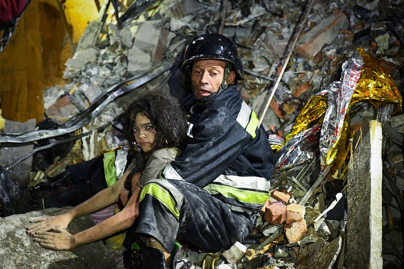 A rescue worker pulls out from under the rubble an injured girl at a hotel damaged by a Russian strike in Zaporizhzhia, Ukraine