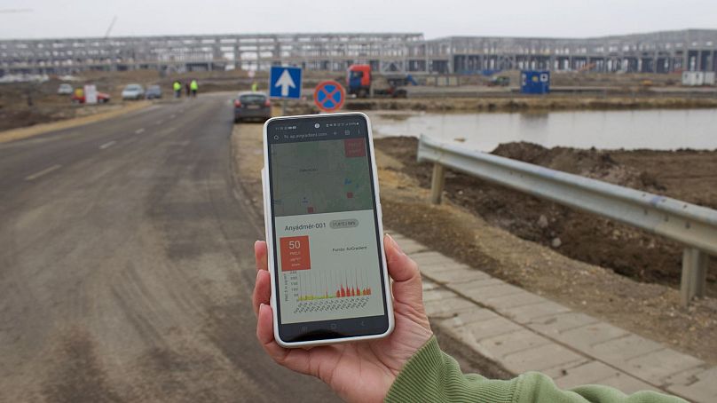 Éva Kozma takes an air quality reading outside the CATL construction site.