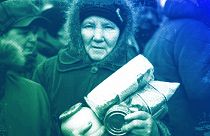 An elderly woman holds humanitarian aid distributed in Popasna, eastern Ukraine, October 2015