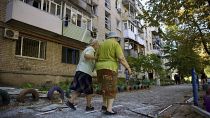 Mujeres locales caminan cerca de un edificio residencial que fue dañado por un ataque ruso en Pavlohrad, 6 de septiembre de 2024.