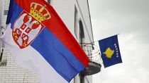 A bandeira sérvia, à esquerda, hasteada num poste de luz em frente a uma bandeira do Kosovo na câmara municipal da cidade de Zubin Potok, 31 de maio de 2023