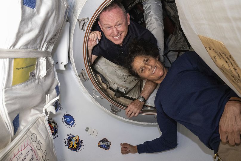 Butch Wilmore y Suni Williams posan para un retrato en el vestíbulo entre el módulo Harmony de la ISS y la nave Starliner de Boeing, 13 de junio de 2024.