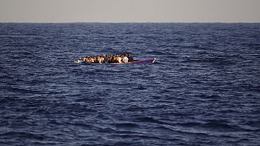 Migrants and refugees fleeing Libya on board of a wooden boat sail at the Mediterranean sea toward the Italian coasts, about 17 miles north of Sabratha, Libya, Sunday, Aug. 28