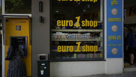 Une femme utilise un distributeur automatique de billets dans la ville principale de l'île de Rhodes, sur la mer Égée, le 10 mai 2022.