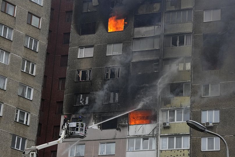 Des pompiers s'efforcent d'éteindre un incendie dans un immeuble d'habitation après une attaque de missiles et de drones russes à Kyiv, le 7 février 2024.
