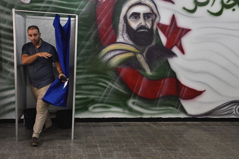 A voter prepares to cast his ballot inside a polling station during the presidential election, Saturday, Sept. 7, 2024, in Algiers, Algeria