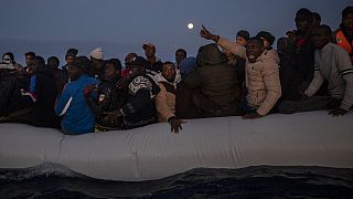 FILE - Migrants on boat in international waters, off the Libyan coast, Jan. 10, 2020