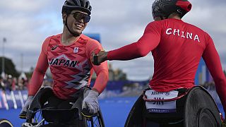 Silver medalist China's Hua Jin, right, and bronze medalist Japan's Tomoki Suzuki greet each other after finishing the men's marathon T54 at the 2024 Paralympics, Sunday, Sept