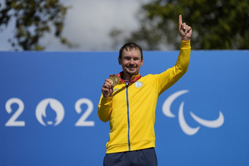 Yehor Dementyev, da Ucrânia, com a sua medalha de ouro depois de vencer a corrida de estrada C4-5 masculina