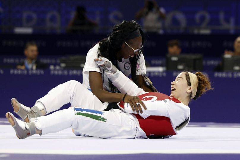 Zakia Khudadadi de l'équipe paralympique des réfugiés, en bas, célèbre sa médaille de bronze en para taekwondo pendant les Jeux paralympiques à Paris, jeudi 29 août 2024.