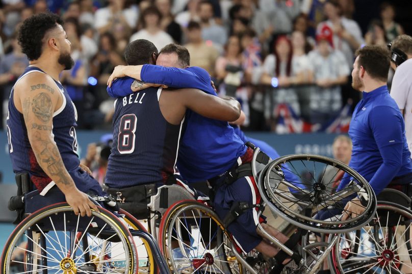 Steve Serio, dos EUA, à direita, abraça o colega de equipa Brian Bell enquanto celebram depois de ganharem a medalha de ouro masculina de basquetebol em cadeira de rodas nos J