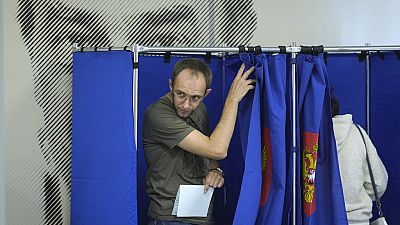 Um homem sai de uma cabina de voto durante as eleições regionais e municipais de três dias em São Petersburgo, Rússia, sexta-feira, 6 de setembro de 2024