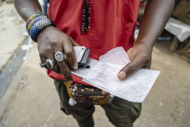 A man sells used cell phones in Dakar's Colobane market, February 2024
