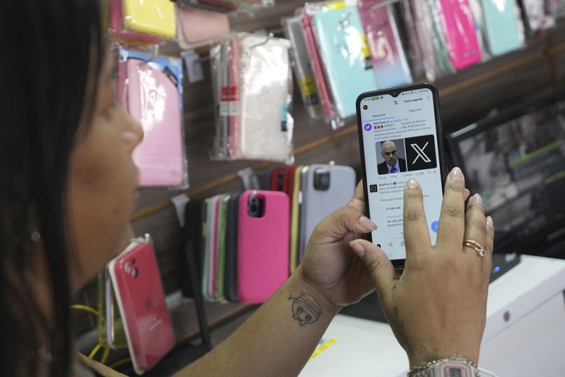 A salesperson at a cell phone case store located inside the bus station in Brasilia, August 2024