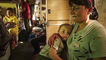 Alla hugs her son Ivan sitting in evacuation train in Pokrovsk, Donetsk region, Ukraine, Monday, Aug. 19, 2024. 