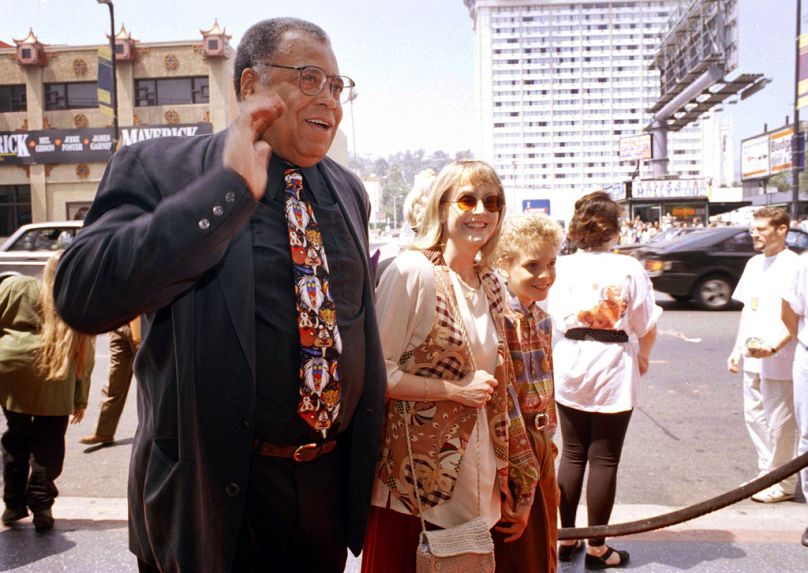 James Earl Jones, à gauche, salue la presse avec sa femme Cecilia, au centre, et son fils Flynn, à droite, lors de la première du « Roi Lion » à Los Angeles, le 12 juin 1994. 