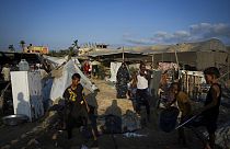 Palestinians look at the destruction after an Israeli airstrike on a crowded tent camp housing Palestinians displaced by the war in Muwasi, Gaza Strip, Tuesday, Sept. 10, 2024